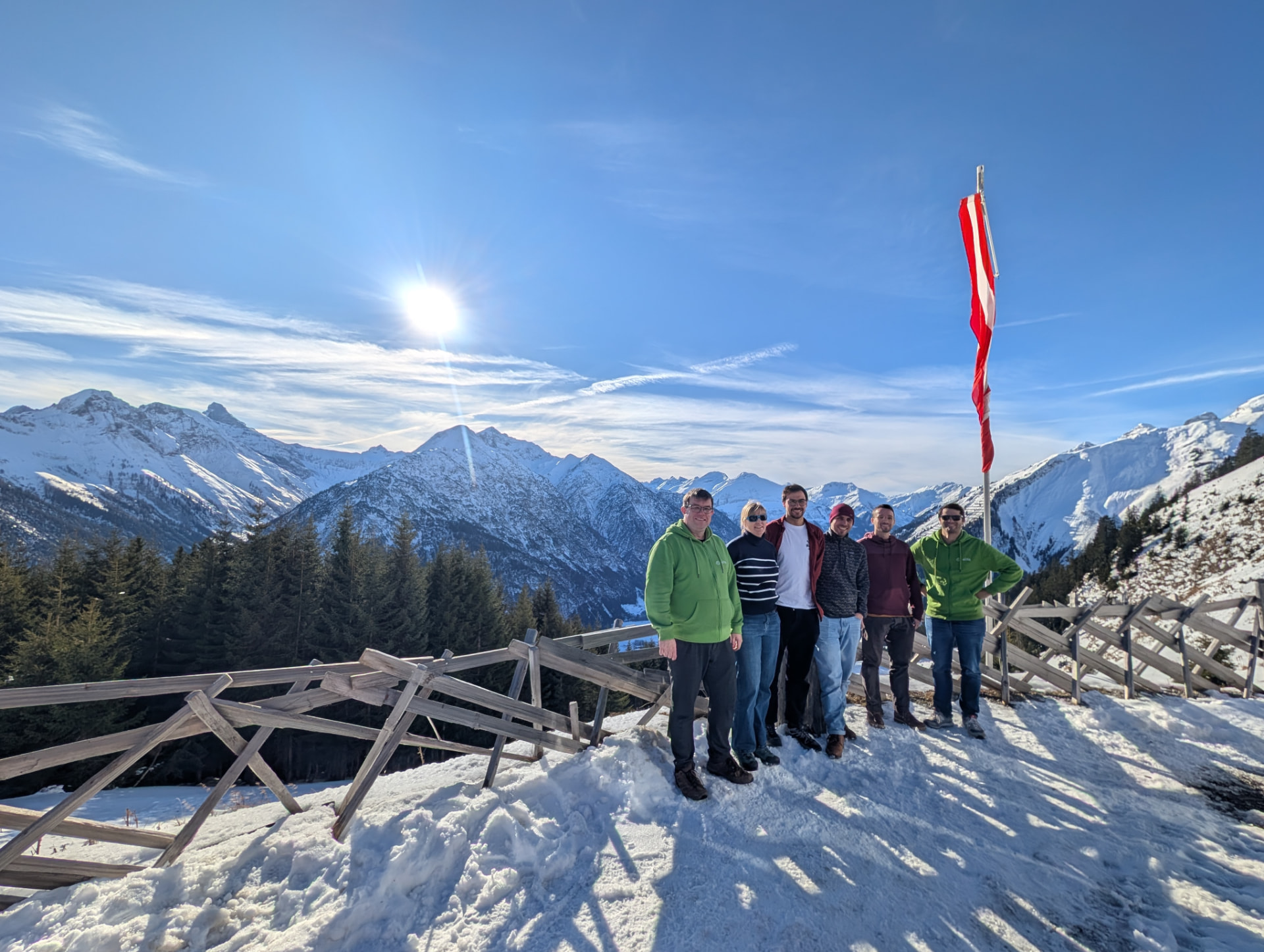 Das alitiq-Team vor einer verschneiten Bergkulisse im Lechtal bei Sonnenschein